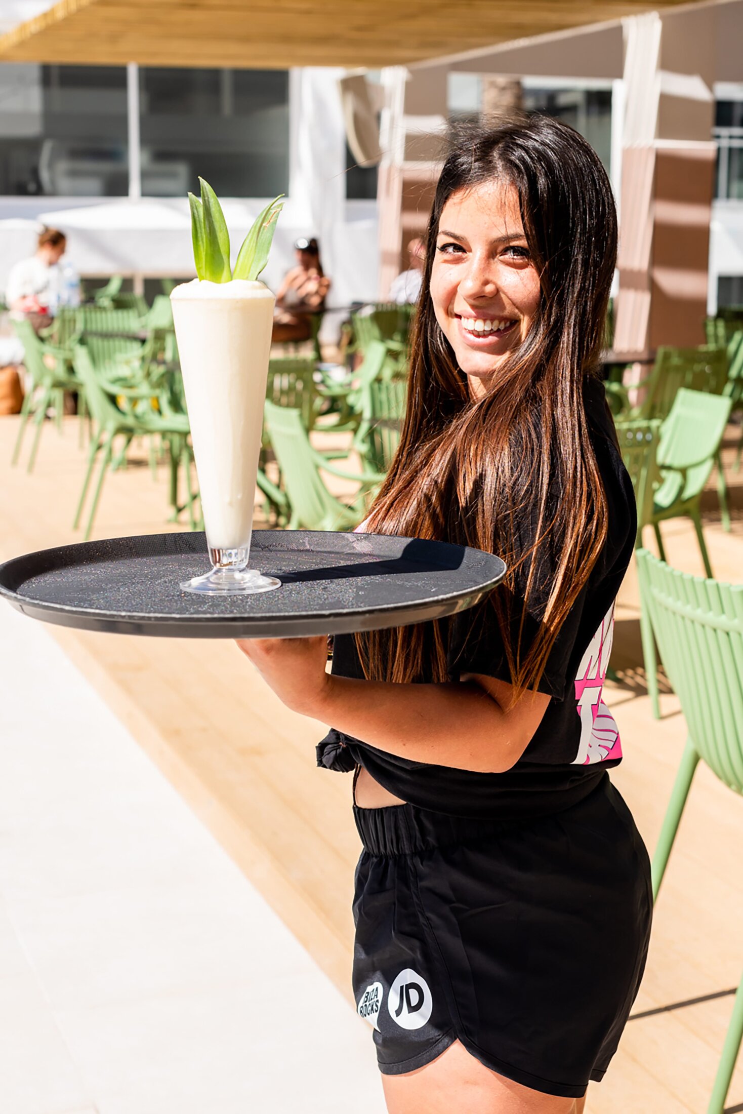 ibiza rocks hotel staff smiling carrying pina colada frozen cocktail at the chill out pool