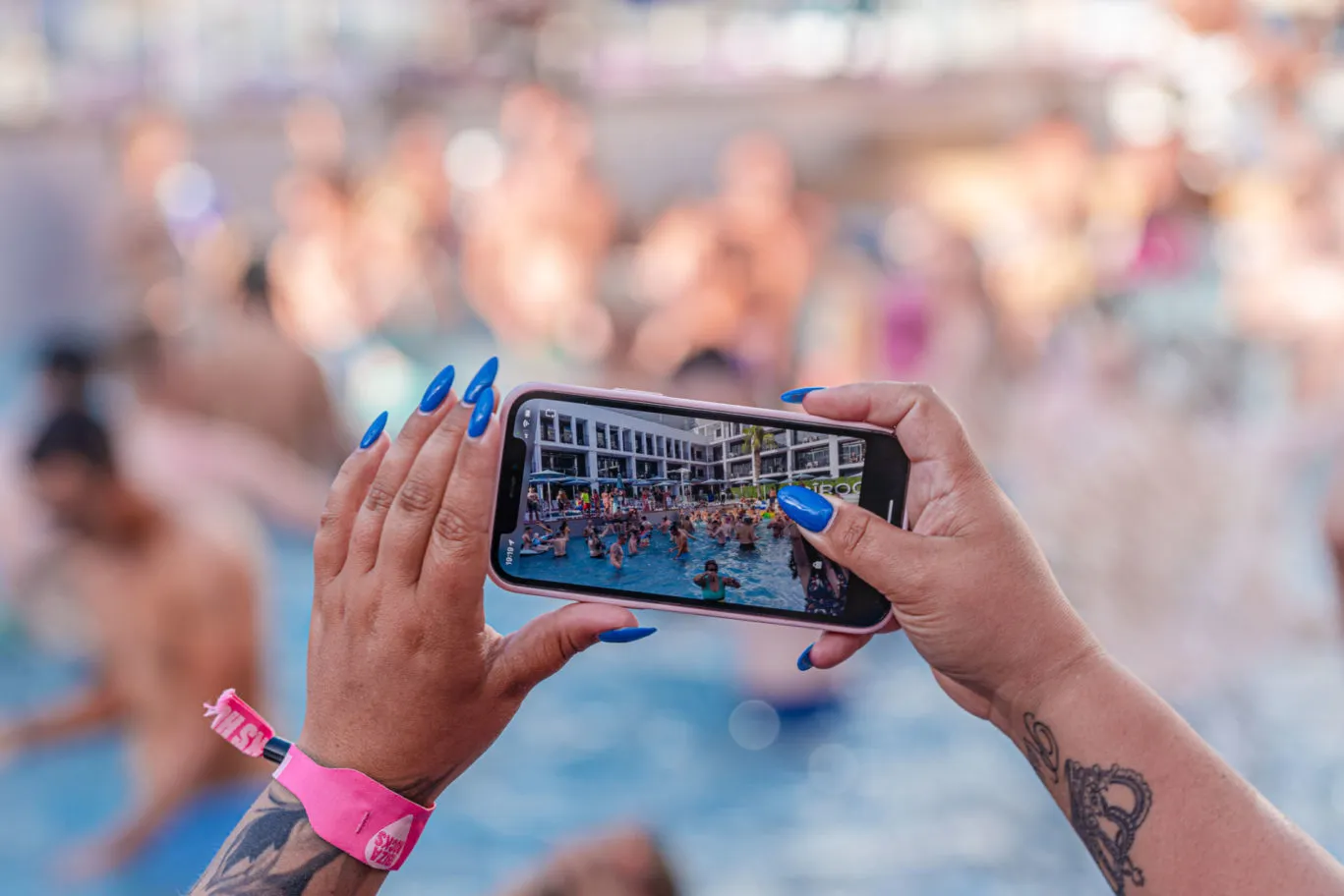 Girl taking a picture of pool with phone Applebum Ibiza Rocks Pool Party