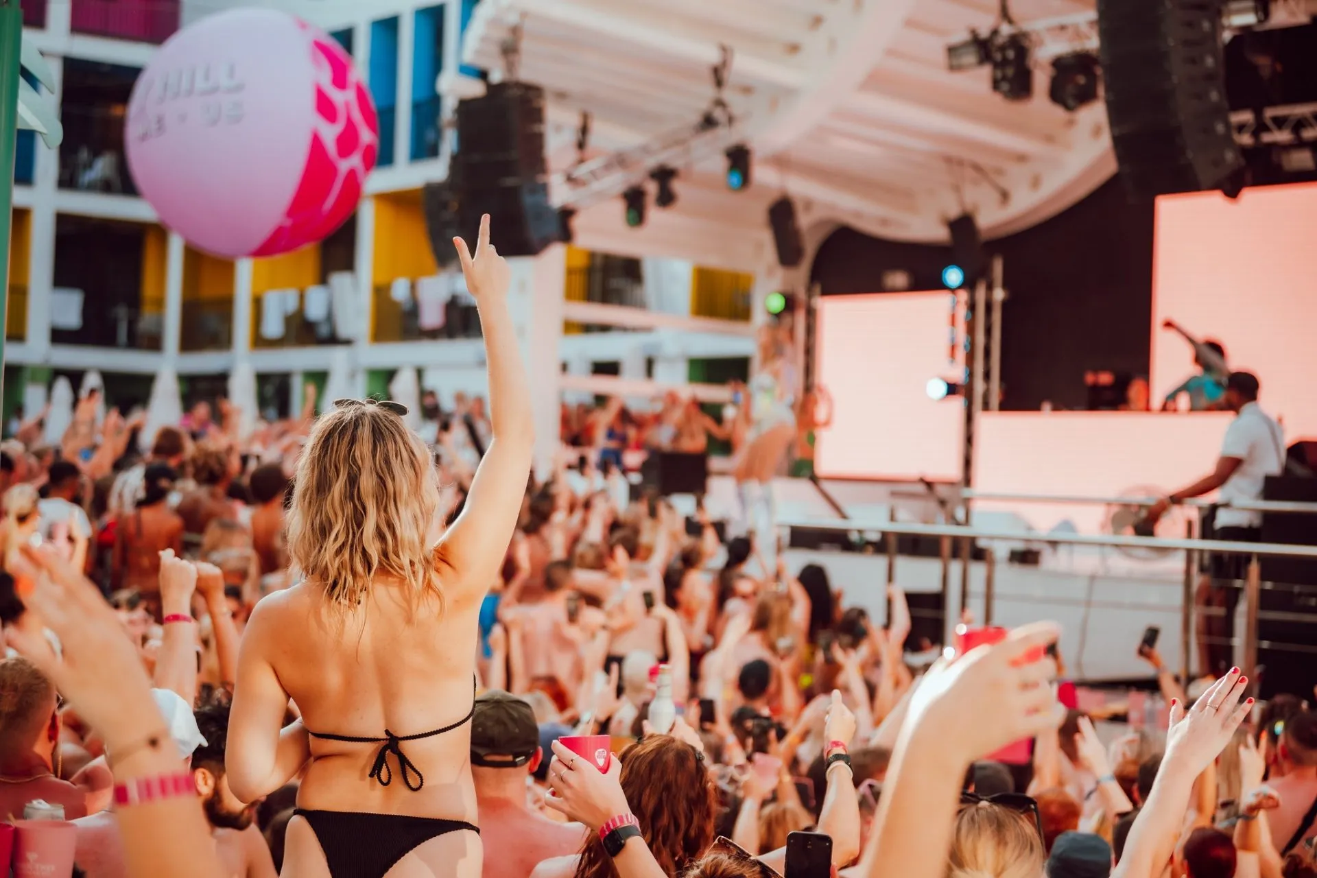 Ibiza 2024 Deposits | Girl by pool looking at stage