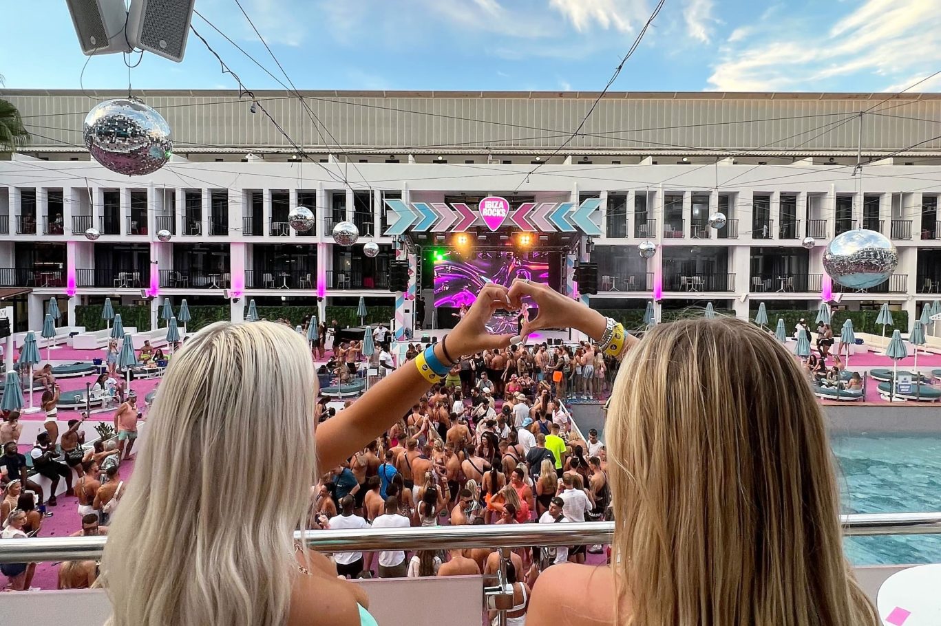Girls making love heart hands on VIP Balcony